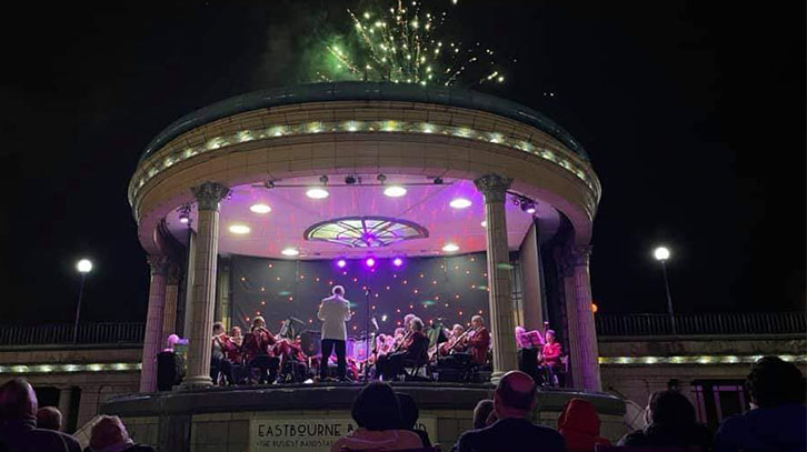 musicians of The Band of the Surrey Yeomanry perform on a bandstand in front of an audience