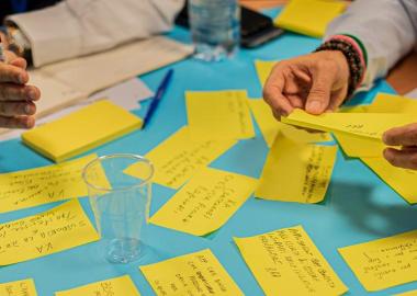 close-up of hands holding yellow sticky notes