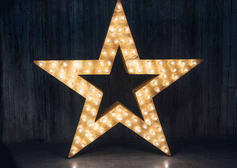 glowing star lit up by lightbulbs against dark background