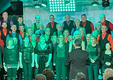 members of various choirs on stage singing