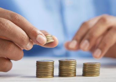 close-up of man's hands stacking coins