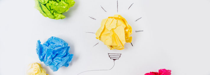 scrunched balls of coloured paper to make up drawing of a light bulb