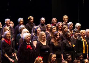 choir members standing up and singing