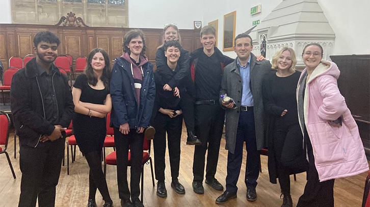 young members of the orchestra pose with the conductor