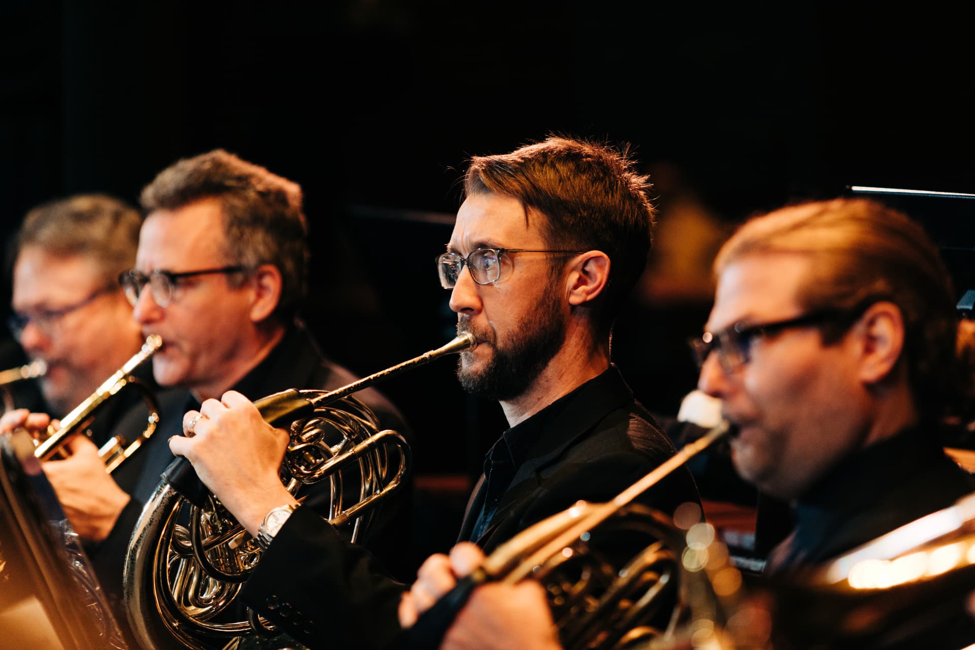 Horn and trumpet players performing in concert